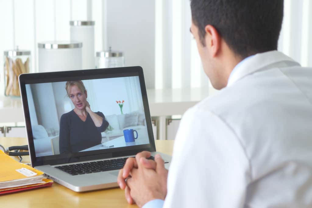 Arzt spricht via Videosprechstunde mit einer Patientin