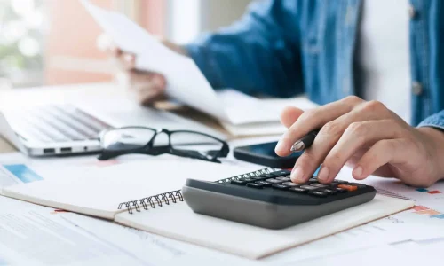 Investors are calculating profits and costs with calculators, growth and investment chart analysis, business planning and strategies to maximize sales profits. Long term business plan.